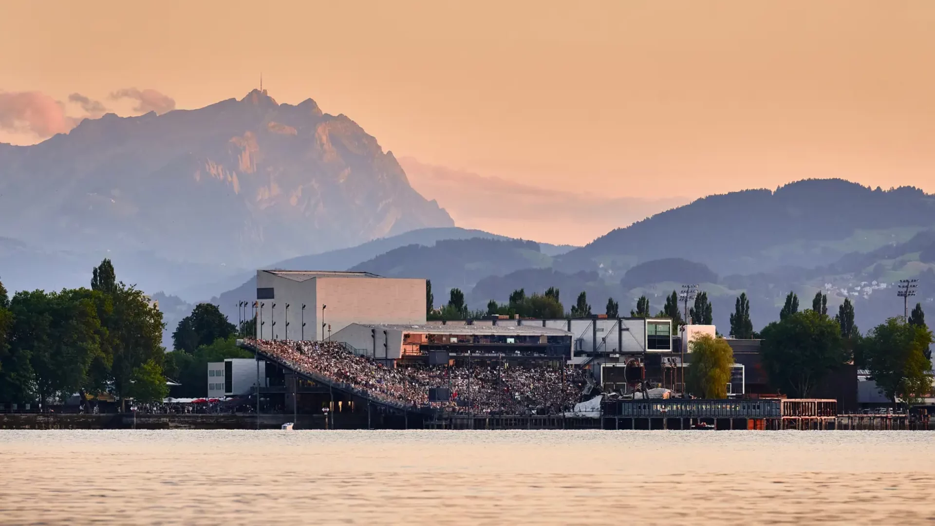Ambiente der Seebühne der Bregenzer Festspiele, Seetribüne mit Publikum bei Abendstimmung vom See aus gesehen