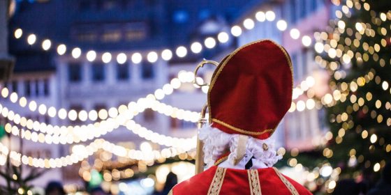 Ein NIkolaus mit Blick auf den mit Girlanden beleuchteten Weihnachtsmarkt in Feldkirch