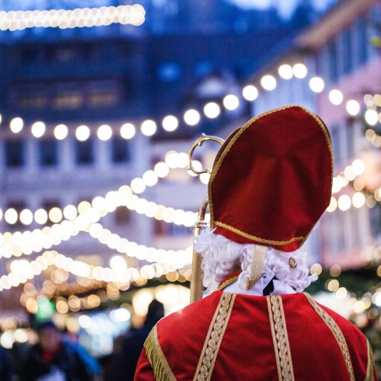 Ein NIkolaus mit Blick auf den mit Girlanden beleuchteten Weihnachtsmarkt in Feldkirch