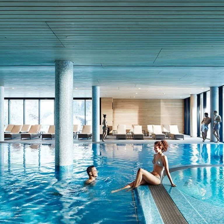 2 Menschen genießen den Indoor Pool im Wellnesshotel Die Wälderin in Mellau, Bregenzerwald