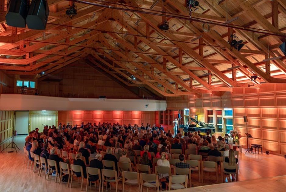 Konzert des :alpenarte Festivals 2024 im Angelika-Kauffmann-Saal in Schwarzenberg, Bregenzerwald. Zuhörer sitzen um einen Flügel auf der Bühne
