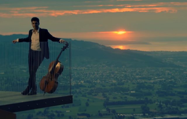 Kian Soltani mit seinem Cello auf der Karrenkante Dornbirn, im Hintergrund Dornbirn und der Bodensee, aus dem Trailer zu HOME (c) youtube / Kian Soltani