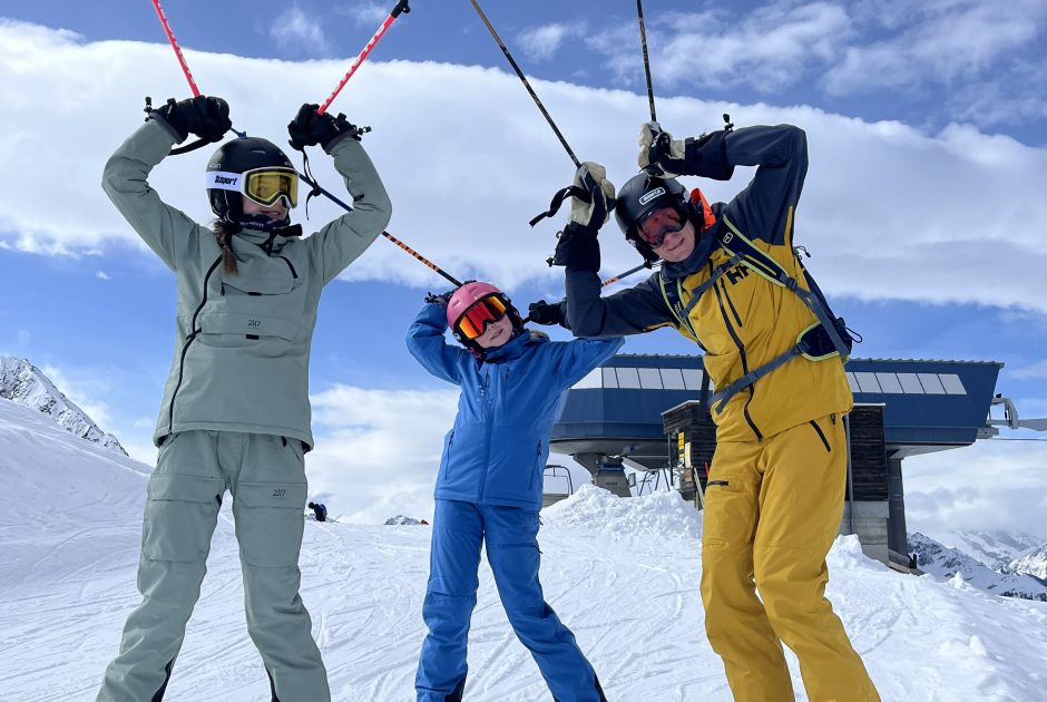 Eine Familie auf Vorarlbergs Skipiste. Sie albern herum und geben vor Giraffen zu sein.