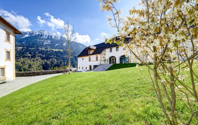 Die Propstei St. Gerold im Frühling, im Hintergrund die Berge des Großen Walsertales, die Bergspitzen noch in Schnee gehüllt, Kultur Frühling in Vorarlberg
