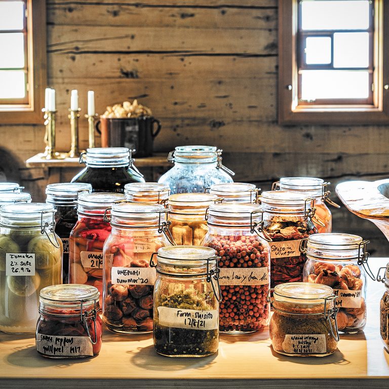 Auf einem Holztisch stehen einige gefüllte Einmachgläser, im Hintergrund eine getäfelte Holzwand.