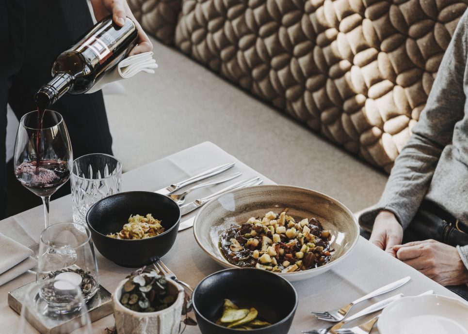 Service Wein einschenken bei gedecktem Tisch mit Hirschpfeffer © Angela Lamprecht / Vorarlberg Tourismus