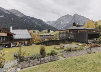 Naturhotel Chesa Valisa von außen im Herbst, im Hintergrund die Kleinwalsertaler Berge
