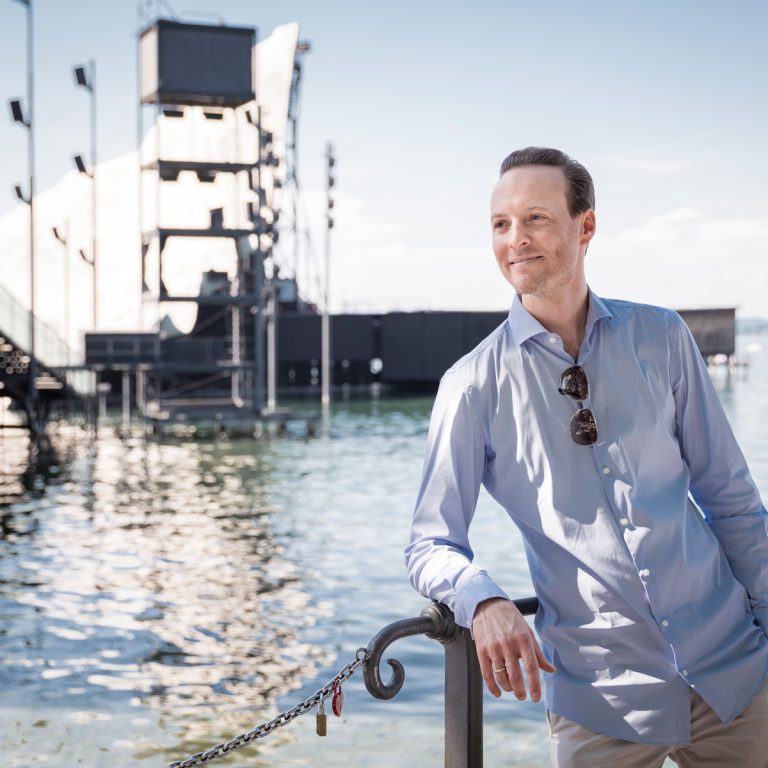 Matthias Honeck, Stimmführer der Wiener Symphoniker und Künstlerischer Leiter der :alpenarte, steht vor der Bregenzer Seebühne am Bodensee; Kulturgeschichte(n)