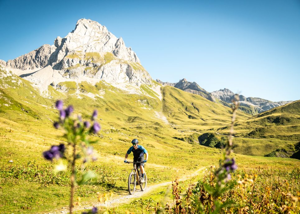 Ein Mountainbiker auf dem Mountainbikepfad entlang des idyllischen Hochgebirg-Stausees Spullersee im spätsommerlichen Klostertal!