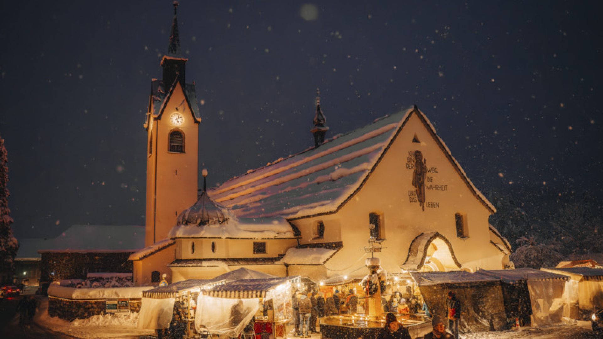Pfarrkirche Schwarzenberg im Winter mit Adventmarkt rundherum