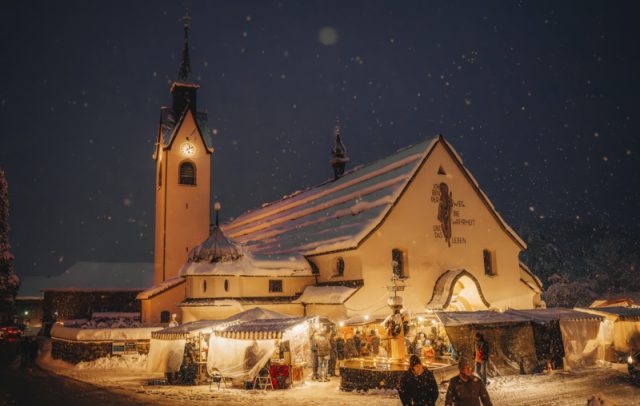 Pfarrkirche Schwarzenberg im Winter mit Adventmarkt rundherum