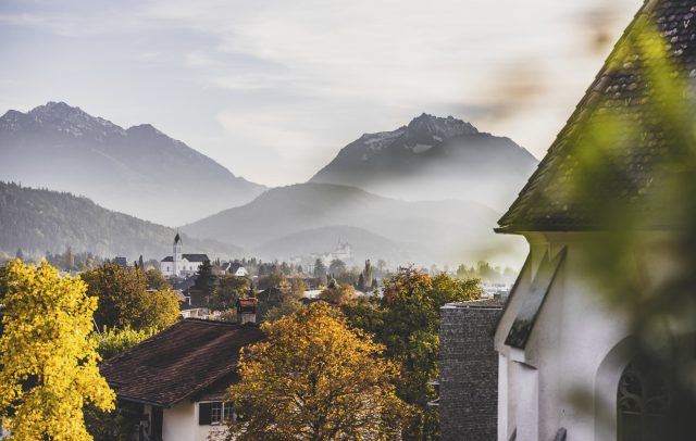 Blick auf das Dorf Sulz in herbstlichem Nebel, bunte Bäume im Vordergrund