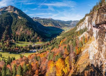 Blick auf das Brandnertal mit herbstlich bunt gefärbtem Wald im Vordergrund