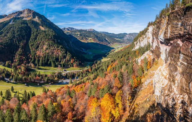 Blick auf das Brandnertal mit herbstlich bunt gefärbtem Wald im Vordergrund