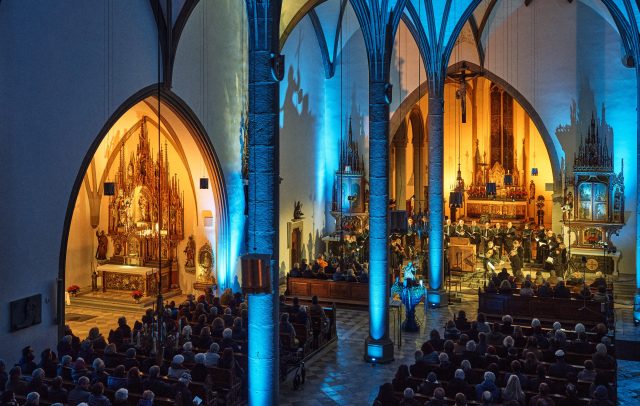 Chorkonzert im Feldkirch Dom, der schön beleuchtet und voll besetzt mit Besuchern ist. Konzert der Montforter Zwischentöne. Kultur Vorarlberg.