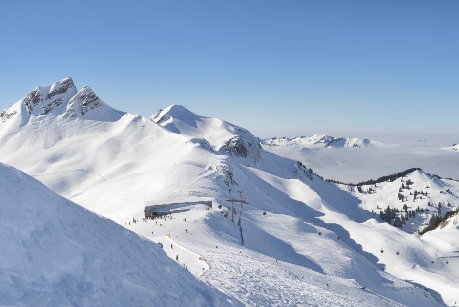 Panoramablick in das tiefverschneite Skigebiet Damüls-Mellau mit der Bergstation der Bergbahnen Mellau im Bregenzerwald