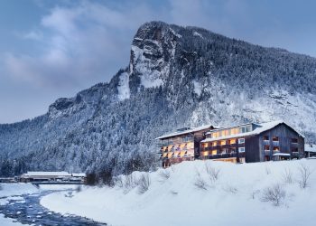 Hotel Krone Au inmitten einer verschneiten Umgebung bei Abendstimmung, Wellnessurlaub Vorarlberg