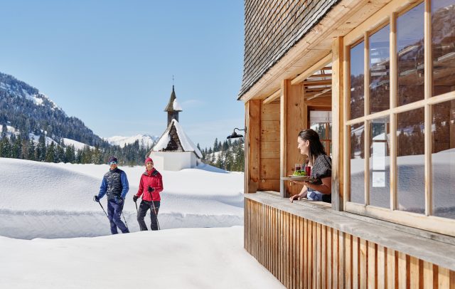 Zwei Winterwanderer im Schnee in Schönenbach, rechts Gasthaus Egender