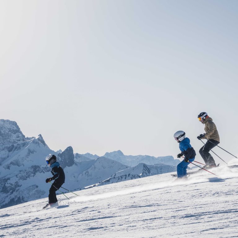 Drei Skifahrer, darunter zwei Kinder, auf der Piste am Diedamskopf
