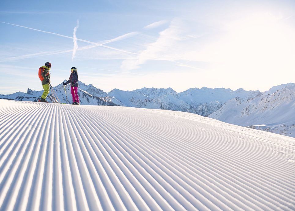 Zwei Skifahrer auf frisch präparierter Piste im Skigebiet Faschina in der Alpenregion Vorarlberg