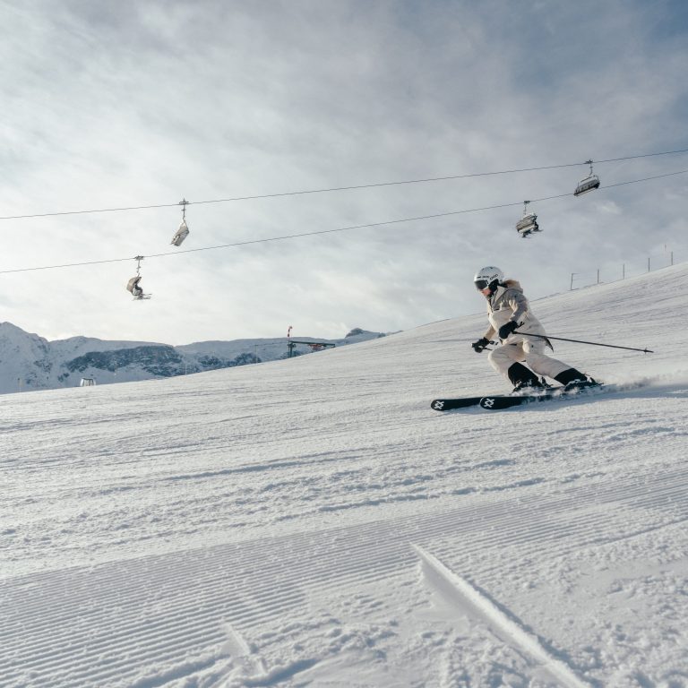 Ein Skifahrer auf der Piste im Skigebiet Golm im Montafon, im Hintergrund der Skilift