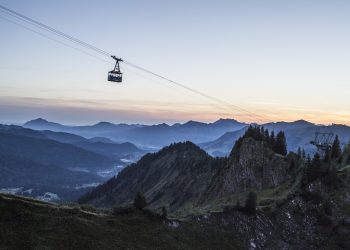 Die Gondel der Walmendringerbergbahn bei Sonnenaufgang, im Hintergrund die Berglandschaft des Kleinwalsertals.