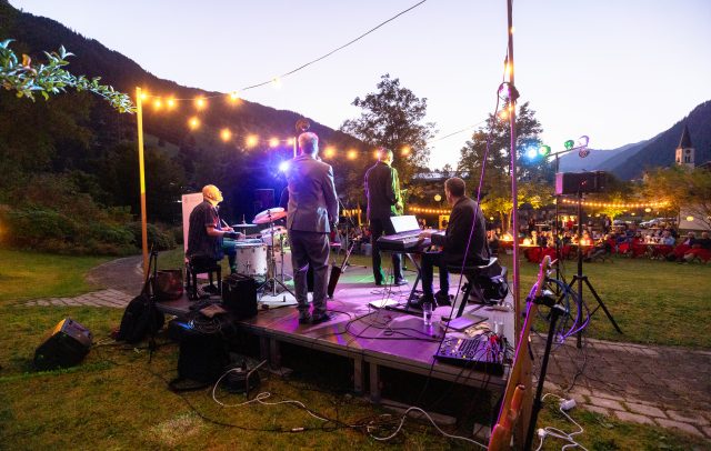 Konzert der Montafoner Resonanzen am Abend, Musiker auf der Bühne open air, viele Lichtergirlanden