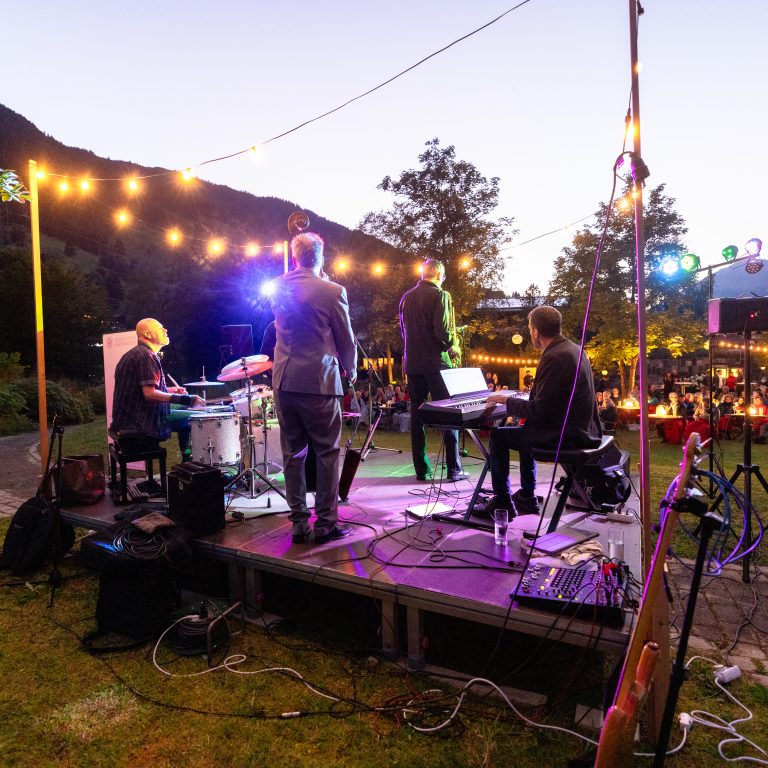 Konzert der Montafoner Resonanzen am Abend, Musiker auf der Bühne open air, viele Lichtergirlanden
