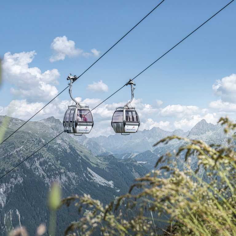 Zwei Gondeln der Versettla Bahn im frühherbstlichen Montafon
